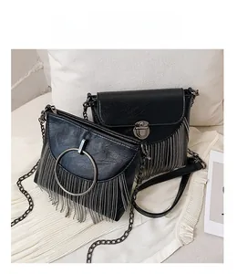 Detail view of black PU crossbody bags with metallic tassels and silver ring accents