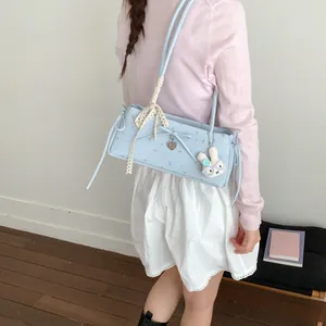 Détail du sac à bandoulière floral bleu clair avec nœud dentelle et breloque lapin
