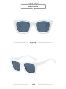 Detail view of white polygon sunglasses with blue lenses and gold metal hinge accents