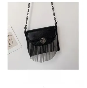 Detail of black pebbled leather crossbody bag with silver fringe and metal chain strap