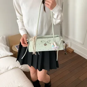 Détail du sac à fleurs vert menthe avec bordure en dentelle et pendentif lapin mignon