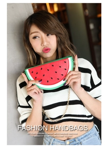Close-up of watermelon-shaped crossbody bag with red and green panels and a gold chain