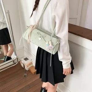 Détail du sac à bandoulière vert clair avec motifs floraux et peluche lapin mignonne