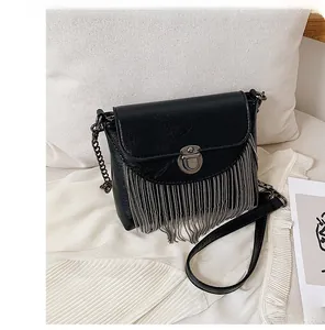 Detail of black PU crossbody bag featuring metallic fringe tassels and round lock buckle