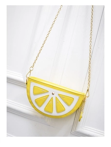 Detail of lemon slice crossbody bag with white stitching and gold chain strap