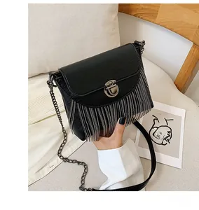 Detail of black PU leather crossbody bag with silver fringe and metal twist lock closure