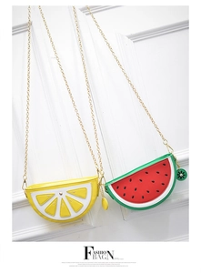Detail view of lemon and watermelon fruit shaped crossbody bags with golden chains