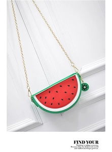 Close-up of watermelon-shaped crossbody bag with red interior and gold chain strap