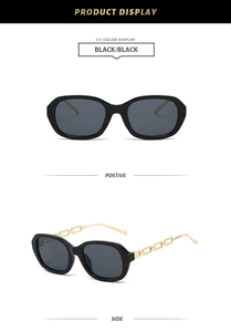 Detail of small oval black sunglasses featuring elegant gold metal chain link temples