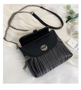Close-up of black PU leather bag with silver metal tassel chains and round twist lock