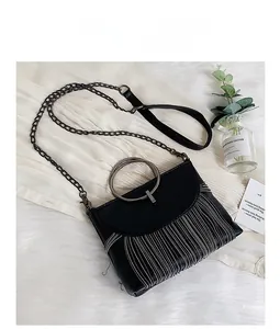 Close-up of black PU leather bag featuring silver beaded fringe and metal ring handle