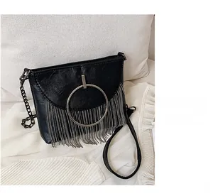 Close-up of black PU leather crossbody bag with silver fringe tassels and metal ring detail