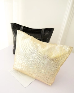Vue détaillée de la texture crocodile sur des sacs à main noir et or en similicuir