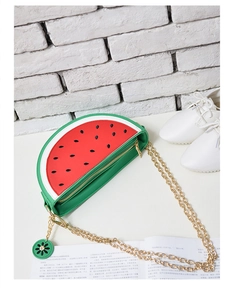 Detail of creative watermelon shaped crossbody bag with red interior and gold chain