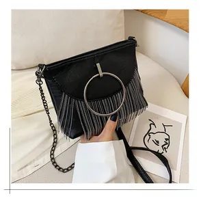 Close-up of black PU leather crossbody bag featuring silver ring and fringe tassel detail