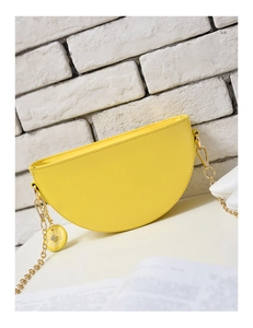 Yellow half-moon saddle bag with golden chain strap and daisy flower charm detail