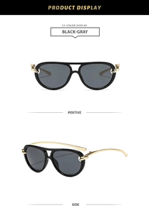 Detail of pilot-style sunglasses in black and gold with grey lenses and metal accents