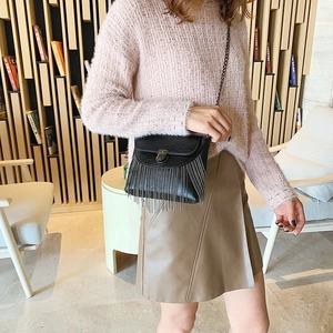 Black PU shoulder bag featuring metallic fringe tassels and a chain strap on model