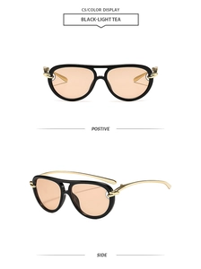 Macro view of aviator sunglasses with black frames, light tea lenses and gold metal accents