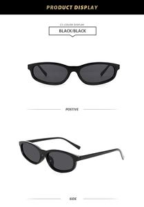Detail view of stylish small oval sunglasses in black frame with dark grey lenses