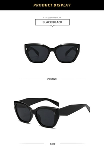 Detail view of black cat-eye sunglasses featuring thick frames and metal dot accents