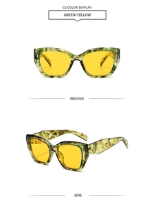 Detail view of cat eye sunglasses with green and yellow tortoiseshell frame and yellow lenses