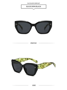 Detail of cat-eye sunglasses with black glossy frames and green marble temples