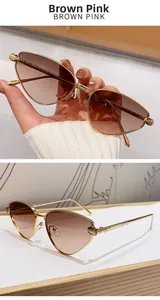 Close-up of golden leopard head emblem on cat eye sunglasses with brown pink lenses