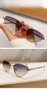 Macro detail of cat-eye sunglasses featuring golden leopard head hinges and gradient lenses