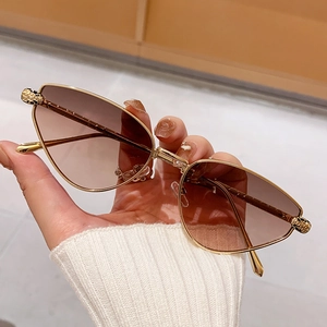 Fashion cat-eye sunglasses with gold metal frame and leopard print detail on the hinges