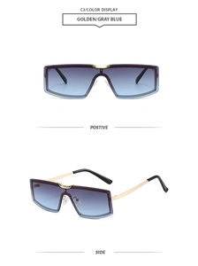 Detail view of large shield sunglasses with golden metal frame and gray blue gradient lenses