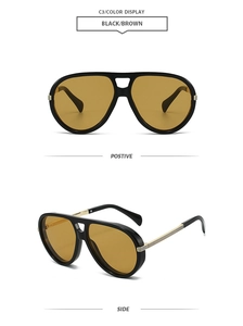 Détail des lunettes aviateur montrant la monture noire et les branches dorées
