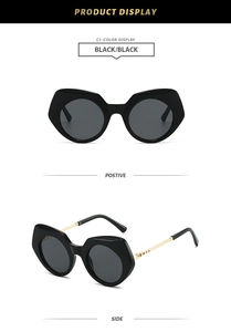 Detailansicht der unregelmäßigen Polygon-Sonnenbrille mit schwarzen Rahmen und Goldbügeln