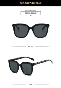 Detail of square sunglasses featuring golden bamboo-shaped metal temples and black frame