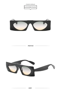 Close-up of black rectangular wide-frame sunglasses with green yellow gradient lenses