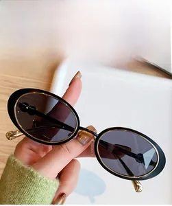 Détail de lunettes de soleil ovales en métal doré avec verres gris pour un style urbain