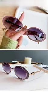 Détail de lunettes de soleil ovales vintage avec monture dorée et verres dégradés