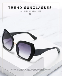 Detail showing UV400 protection and golden hinges on black hexagon oversized sunglasses