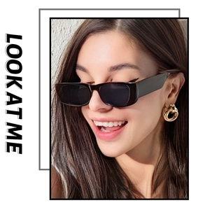 Gros plan de lunettes de soleil rectangulaires noires portées avec boucles d'oreilles