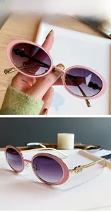 Lunettes de soleil ovales roses avec branches en métal doré et verres dégradés gris