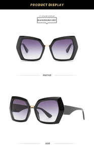 Detail view of large geometric sunglasses with black frames and purple gradient lenses