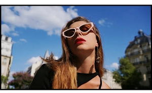 Portrait extérieur d'un mannequin portant des lunettes de soleil œil-de-chat rétro roses