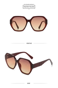 Detail view of tea yellow gradient lenses and geometric dark red frame sunglasses