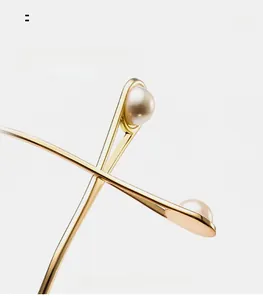 Detail of curved metal temples with inlaid pearl tips for stylish sunglasses