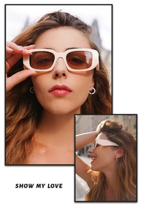 Close-up of beige rectangular sunglasses with brown lenses on a model outdoors