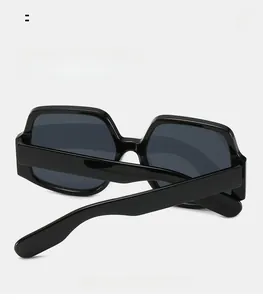 Dettaglio occhiali da sole con montatura nera spessa e stanghette curve per il comfort