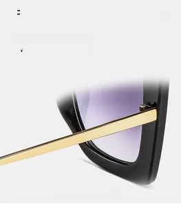 Detail of square oversized sunglasses with gold metal temples and gradient purple lenses