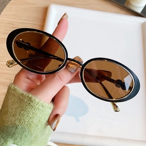 Lunettes de soleil ovales vintage avec monture noire épaisse et verres teintés rétro