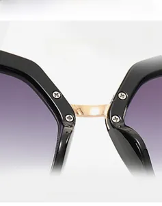 Detail of purple gradient lenses and gold metal bridge on black oversized sunglasses
