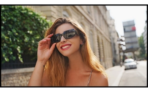 Outdoor portrait of a model wearing retro black rectangular thick frame sunglasses